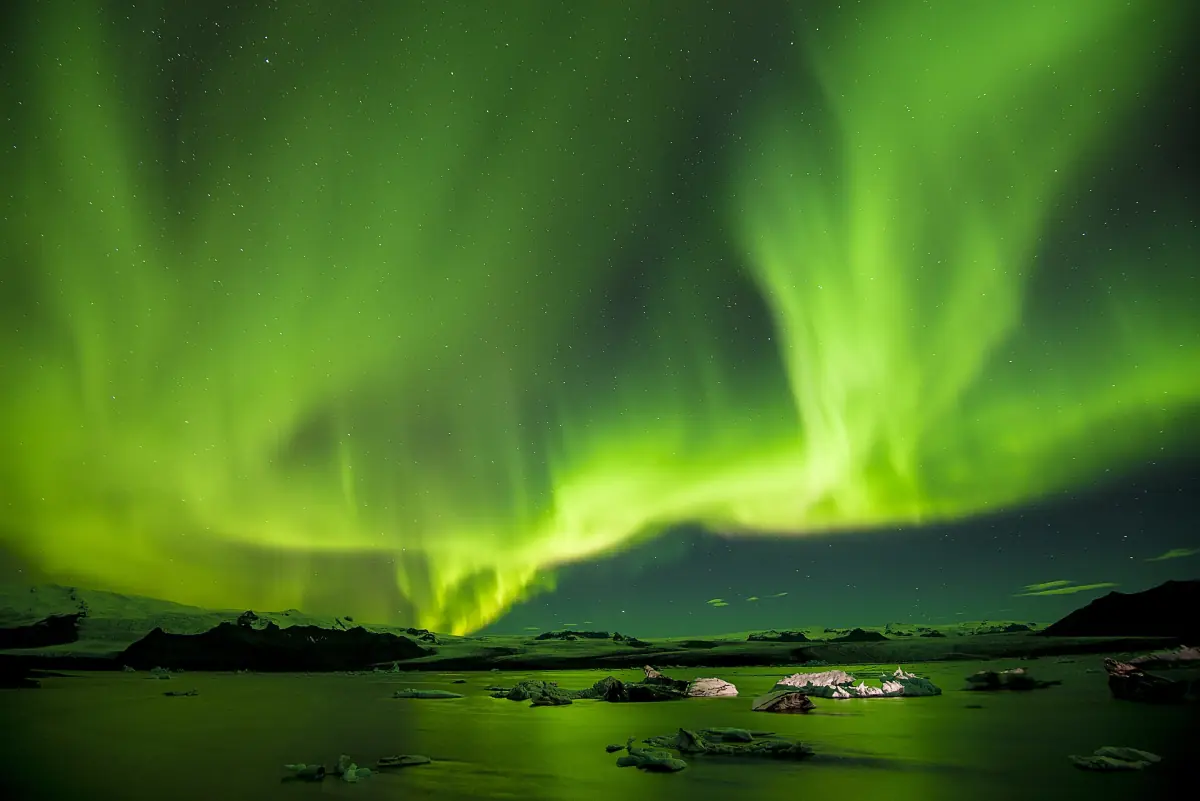 Aurores boréales d’un vert vif au-dessus d’un lac en Islande